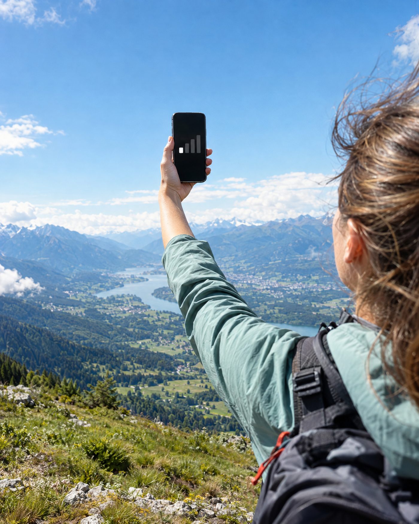 Holding a phone up over an alpine valley